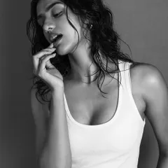 A simple, classic portrait in black and white. The focus is on the model's expression and the soft light that sculpts her features. The monochrome style gives the image a timeless, intimate, and slightly vulnerable feel.