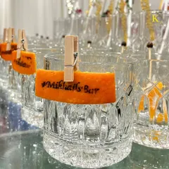 A close-up of our custom heat-stamped garnish. We can burn a hashtag, logo, or initials onto citrus peels, adding a unique and highly personalized branding element to your cocktails.
