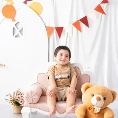 A relaxed and happy portrait of a toddler sitting with his teddy bear friend. I create a comfortable environment where kids can be themselves.