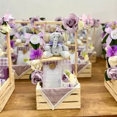 Announcing the arrival of a precious baby girl with these enchanting hampers. Centered around a sweet, handcrafted crochet elephant on a swing, these gifts are curated with a soft lavender palette, personalized notes, and delicate floral touches for a truly heartwarming reveal.