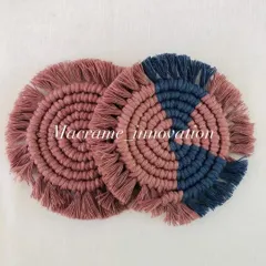 A set of handmade macrame coasters, one in solid dusty rose and the other in a two-tone combination with navy blue. These add a lovely handmade texture to your coffee table.