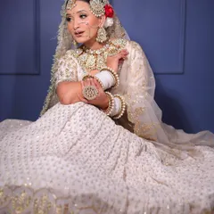 A full-length view showcasing the flow and design of the white and gold embroidered lehenga. The complete jewellery set, including the chooda covers, brings the entire bridal vision to life.