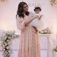 Another sweet moment between mother and daughter in front of the elegant floral backdrop.