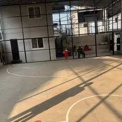A young girl runs with the ball on the court, showing the dynamic movement and energy of our basketball sessions.
