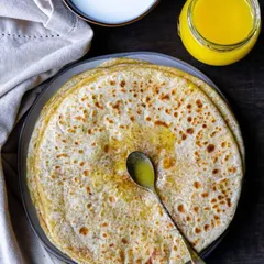 A close-up of our soft and delicious Puranpoli, generously topped with ghee. This Maharashtrian delicacy is a highlight of our festive menu, made fresh to order for your celebrations.