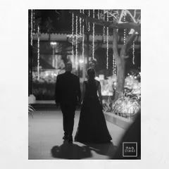 A romantic black and white photo of a couple walking away under twinkling lights. This shot feels like a scene from a classic movie, full of mood and elegance.