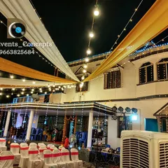 An elegant house lighting and draping setup for a home-based event. The combination of string lights and flowing fabric transforms the exterior into a beautiful event space.