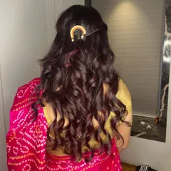 A beautiful half-up, half-down hairstyle with soft curls. I added a simple, elegant hair accessory to complete the look for her festive occasion.