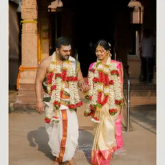 A candid moment of the newly married couple after their South Indian wedding ceremony, walking hand-in-hand in traditional attire.