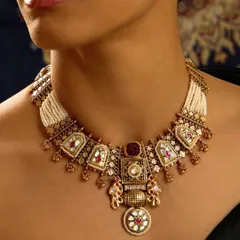 A necklace that tells a story of royalty. This heritage piece features intricate architecture-inspired motifs, elephant figures, and a beautiful blend of polki, enamel, and pearls.