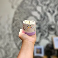 This terrazzo candle features a custom blend of colorful chips in a white base with a solid lavender bottom. The jar is made from durable, eco-friendly resin and can be repurposed after use.