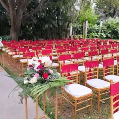 The guest seating is an integral part of the ceremony's design. Here, chairs are adorned with matching red sashes, ensuring the entire venue reflects the chosen color palette and theme.