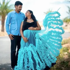 We love creating dynamic and joyful portraits. Here, we used a flowing maternity gown to add a sense of movement and elegance against a simple outdoor path, highlighting the couple's happy anticipation.