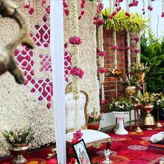 An artfully framed shot of the Seemantham setup, showing the elegant white chair for the mother-to-be and the traditional brass lamps. We focus on creating a space that is both beautiful and functional for the rituals.