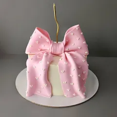 A simple yet stunning pink bow cake. This elegant design is perfect for any celebration for her, from birthdays to anniversaries. The oversized fondant bow makes a beautiful statement.