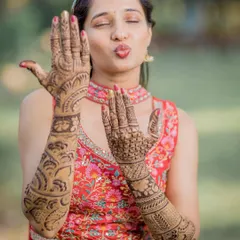 A playful bride shows off her elaborate Mehendi design, a beautiful and essential part of the pre-wedding preparations.