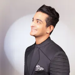 A close-up of the achkan, highlighting the pleated sleeve details and the subtle sheen of the fabric, complete with a patterned pocket square.