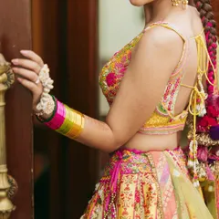 A close-up on the details. The colorful bangles, the floral hand jewelry, and the peek of her pleated braid all come together beautifully.