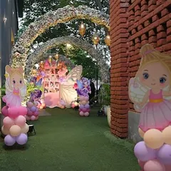 A view down the garden path, lined with fairy cutouts and balloon columns, leading to the main butterfly-themed backdrop. We love creating an immersive journey for guests.