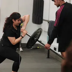 A member performs a landmine rotational exercise, a fantastic move for building core stability. Our coaches are always on hand to guide and assist.