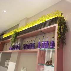 Even a simple retail shelf can become a design feature. Here, I used black fluted panels as a backdrop and integrated bright artificial greenery with backlighting to draw attention to the products and add a vibrant, modern touch to the display.