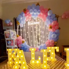 A 'Welcome Home' party for a newborn. This features a pink and blue balloon ring, a 'Welcome' neon sign, 'BABY' blocks, and the baby's name in marquee letters.