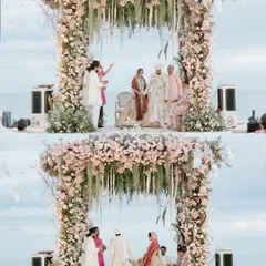 A wide-angle view of a stunning beachside wedding ceremony in Thailand, showing the grand floral mandap set against the ocean backdrop.