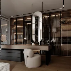 This design integrates a floating vanity directly into the walk-in closet system. The hanging oval mirror and modern stool create a chic spot for getting ready, surrounded by smoked glass wardrobes that showcase the clothing within.