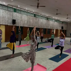 Young women at the Lila Poonawalla Foundation practicing Tree Pose (Vrikshasana). This balancing posture helps improve concentration and builds physical and mental stability.