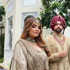 A portrait of modern royalty. The couple's coordinated ivory ensembles are a testament to understated luxury, perfect for a sophisticated daytime wedding ceremony.