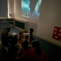 We continued our journey into space by watching a video about asteroids. Using a projector to create an immersive experience helps capture the children's imagination and makes learning feel magical.