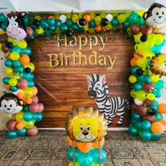 A jungle theme backdrop with a wood-panel look. The balloon arch is filled with animal characters like a monkey, lion, and zebra.