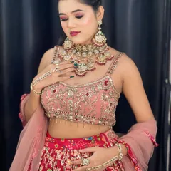 A detailed shot of a modern party look. The makeup features dramatic pink and purple eyeshadow, highlighted cheeks, and a bold lip, perfect for an evening event or sangeet.