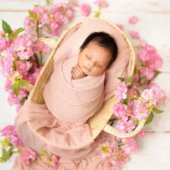 Another angle of this beautiful floral setup, showing the baby peacefully asleep in a woven basket on a bed of pink flowers. This highlights the artistry of my prop styling.