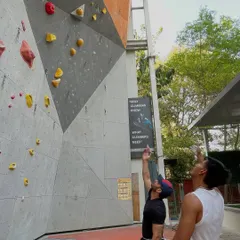 Two climbers discuss strategy before attempting a route on our outdoor lead wall. Beta sharing, or sharing tips, is a huge part of the climbing community.