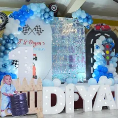 Ready, set, go! This car-themed first birthday party was a huge hit. We created a complete race track experience with custom backdrops, a shimmer wall, marquee letters, and fun details like traffic lights and tire props.