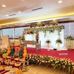 A wide shot of the naming ceremony stage, showing the full floral arrangement and guest offerings.