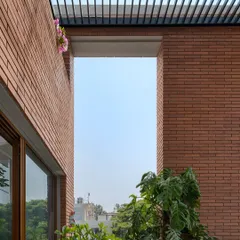 Here, we used exposed brick walls and a slatted pergola to frame a perfect view of the sky. The structure is designed to capture light and cast linear shadows, adding depth and pattern to this outdoor space.