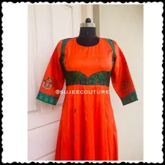 A closer look at the bodice of the orange and green Anarkali gown. The design features a sweetheart neckline on the yoke and delicate embroidery on the sleeve cuffs.