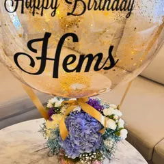My signature hot air balloon arrangement is a client favorite. Here, I paired a beautiful box of blue hydrangeas, white roses, and carnations with a custom gold-flecked bubble balloon for a special birthday celebration.