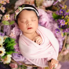 Another angle from the floral basket setup, showing the baby's tiny feet peeking out from the swaddle. It is these little details that make your newborn's portraits so special.