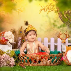 Celebrating tradition with a divine little Krishna photoshoot. I provide the complete setup, including the costume, peacock feather crown, and an enchanted garden backdrop, to create a truly special portrait for Janmashtami or any occasion.