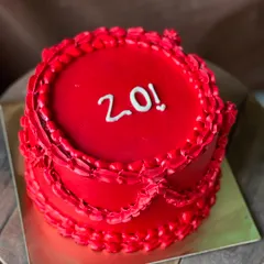 A vibrant, all-red cake to celebrate a 20th birthday. The vintage-style piping gives it a unique, dramatic look.