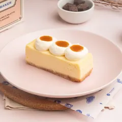 A slice of my classic Caramel Cheesecake, with a smooth baked cheesecake base and topped with dollops of whipped cream and a rich caramel sauce.