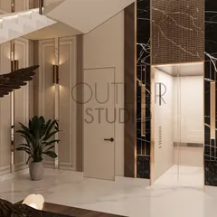 Designing a grand staircase and lift lobby that feels like a masterpiece. This view shows the elegant lift entrance, clad in black marble with gold inlay, complementing the neutral wall paneling.