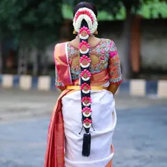 This is a perfect example of how a blouse back can complete a bridal look. The peacock embroidery is stunning, and the design works in harmony with the bride's traditional floral hair accessories.