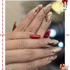 Another view of this festive red and gold set. The combination of sparkling glitter and intricate art on these almond-shaped nails is perfect for the holiday season.