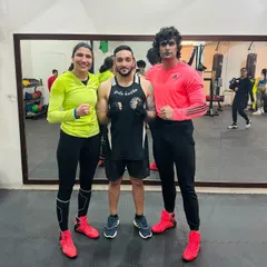 We host workshops and train with high-level athletes to constantly elevate our skills. Here, our coach stands with professional boxers after an intense training session at our academy.