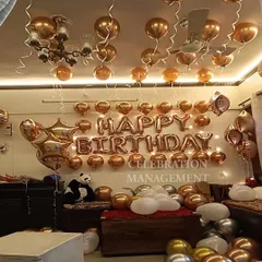 A classic and elegant room decoration using rose gold and silver balloons. The 'Happy Birthday' foil banner is the centerpiece, with balloons floating on the ceiling and scattered on the floor to fill the space.