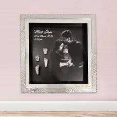 For a modern and heartfelt tribute, I can combine your family's first portrait with the delicate silver casts of your baby’s hands and feet. This design features a stunning silver textured frame and a classic black and white photograph, creating a sophisticated piece of art for your home.